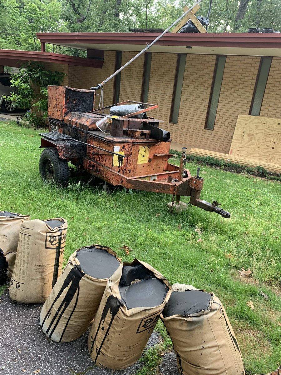 Hot asphalt kettle and built-up roofing asphalt on a repair job